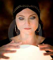 immagine raffigurante una operatrice esoterica con le mani sulla sfera di cristallo